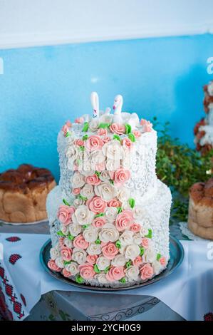 Elégant gâteau à deux niveaux orné de décorations florales. Banque D'Images