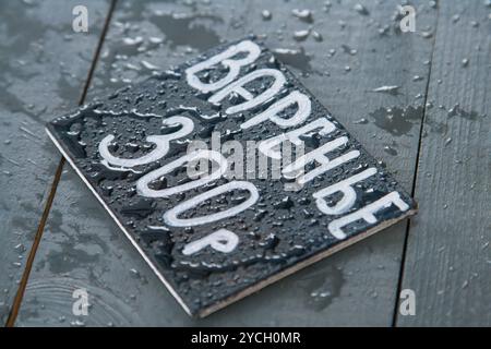 Liste de prix sur la plaque en bois noir avec de l'eau baisse Banque D'Images