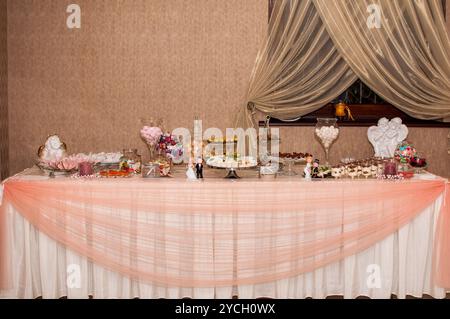 Elégante table de desserts de célébration avec des friandises somptueuses et des accents décoratifs. Banque D'Images