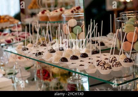 Présentation élégante de desserts gourmands assortis sur une table en verre. Banque D'Images