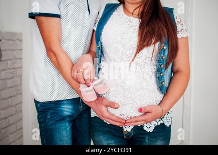 Un joyeux couple attendant célébrant leur nouvelle arrivée avec Baby Shoes. Banque D'Images