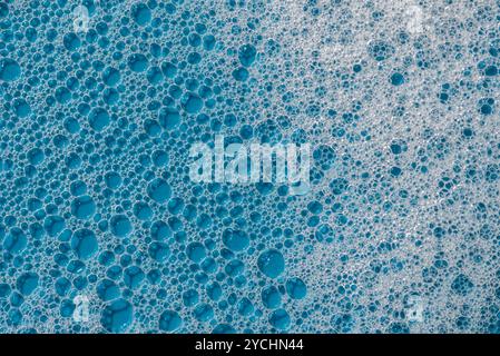 Arrière-plan et motif. Mousse de savon blanc avec des bulles, texture sur fond de tuile bleu. Bulle de mousse détergente sur le carreau. gel douche, mousse shampooing pour cheveux sm Banque D'Images