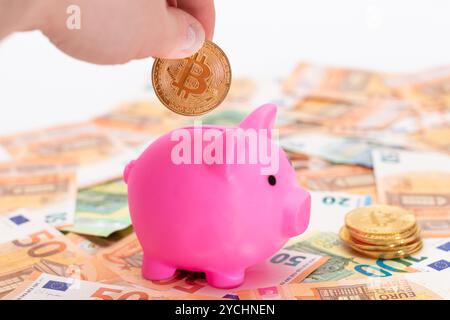 Pink Piggy Bank avec Bitcoin coin sur les billets de Fifty Euro. Petite boîte d'argent pour l'argent et les pièces de monnaie. Concept d'économie d'argent Banque D'Images