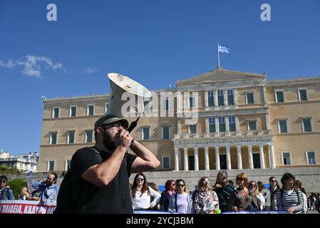 Les enseignants grecs protestent pour une meilleure rémunération Un manifestant chante des slogans utilisant un mégaphone alors que les enseignants des écoles maternelles et primaires manifestent devant le Parlement grec pour exiger des augmentations de salaire. Athènes Grèce Copyright : xNicolasxKoutsokostasxNicolasxKoutsokostasx DSC 202410230513 Banque D'Images