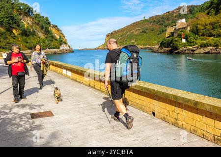 Un pèlerin marchant le long de la promenade de la baie de Pasajes. Route nord du Camino de Santiago. Pasajes de San Pedro, Gipuzkoa, Espagne. Banque D'Images