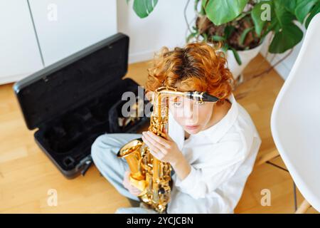 portrait jeune femme attirante aux cheveux roux jouant du saxophone, Banque D'Images