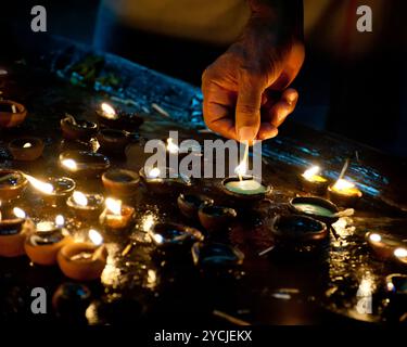 Les gens brûlant des lampes à huile comme rituel religieux Banque D'Images