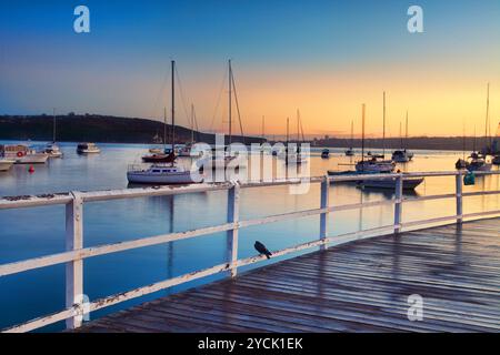 Bateaux amarrés dansant dans les eaux au lever du soleil Banque D'Images