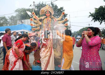 Festival Durga Puja à Kolkata, Inde les dévots offrent des prières et exécutent des rituels avant d'immerger une idole de la déesse hindoue Durga dans la rivière Hoosely comme rituel pendant le festival Durga Puja, à Kolkata, Inde, le 13 octobre 2024. Durga Puja est un festival hindou majeur en Inde, célébrant la victoire de la déesse Durga sur le démon Mahishasura, symbolisant le triomphe du bien sur le mal. Il implique des rituels dynamiques, des structures décorées de grands pandals, des spectacles culturels et des processions, en particulier au Bengale occidental, en Assam et dans d'autres états indiens orientaux. Kolkata Inde Copyright : XMA Banque D'Images