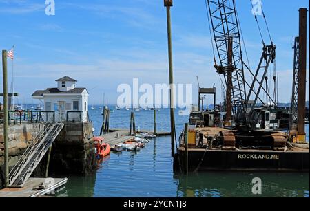 Les ouvriers de la construction installent de nouveaux pilotis en bois pour le quai au débarcadère public dans le port, Rockland, Maine Banque D'Images