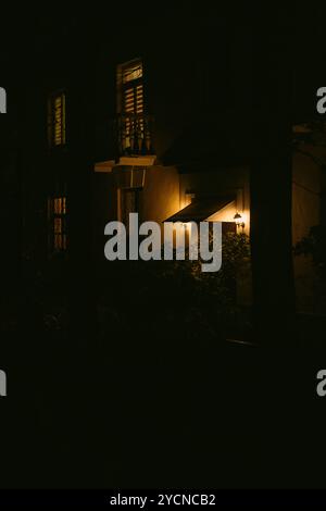 Lueur douce d'une lumière de porche illumine une soirée sombre dans un quartier calme Banque D'Images