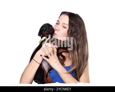 Fille embrassant son chiot doberman Banque D'Images