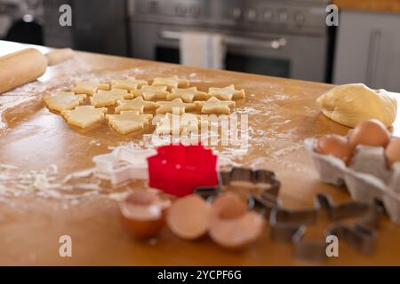 Cuire des biscuits de Noël à la maison avec de la pâte et des emporte-pièces sur la table Banque D'Images