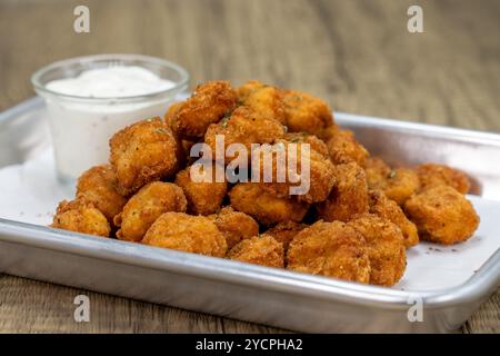 Ordre croustillant de nuggets de poulet pop-corn sur un plateau avec sauce ranch. Banque D'Images