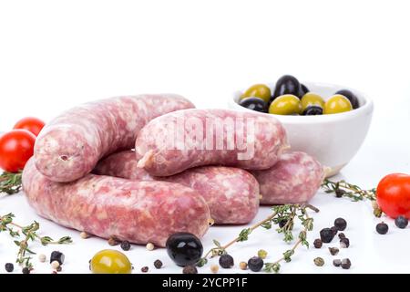 Les saucisses crues non cuites avec des épices sur fond blanc Banque D'Images