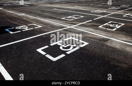 Places de parking pour personnes à mobilité réduite ou handicapées Signes et lignes de marquage sur l'asphalte Banque D'Images