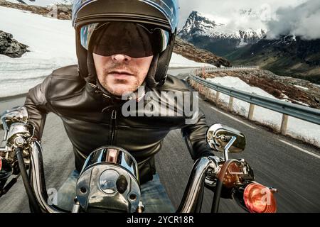 Biker veste en cuir et casque en course de montagne sur serpentine. Banque D'Images