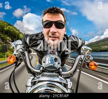 Funny Biker veste en cuir et lunettes en course de montagne sur serpentine. Banque D'Images