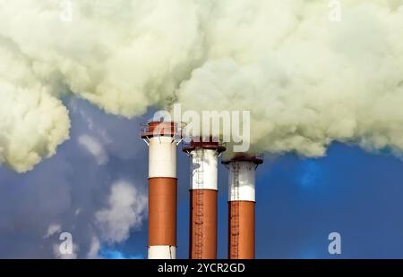 Cheminées industrielles avec plus de fumée ciel bleu Banque D'Images