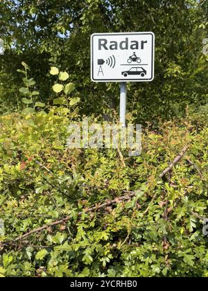 Panneau avec inscription radar sur lui symboles de radar de voiture de moto de dispositif radar dépasse de sur la haie, Rhénanie du Nord-Westphalie, Allemagne, Europe Banque D'Images