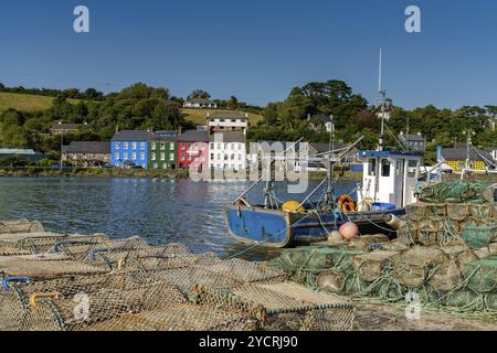 Bantry, Irlande -12 août, 2022: Vieux bateau de pêche en bois et filets de pêche et casiers à crabes dans la baie de Bantry avec le centre-ville de Bantry en arrière-plan Banque D'Images