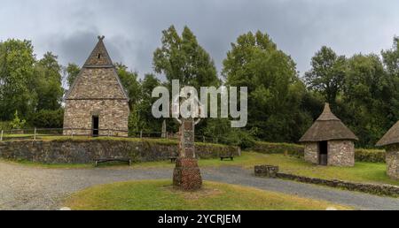 Wexford, Irlande, 18 août 2022 : vue d'un monastère chrétien reconstruit dans le parc du patrimoine national irlandais avec une grande croix celtique Banque D'Images