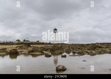 Vue sur le phare historique de la Southerness en Écosse avec réflexions dans les bassins de marée en premier plan Banque D'Images