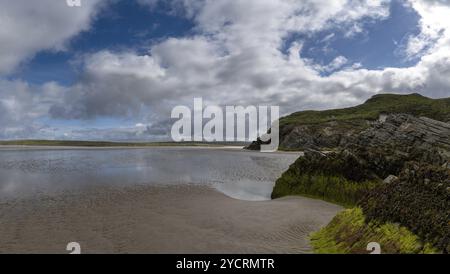 Vue sur la pittoresque plage de sable doré de Maghera avec des rochers et des falaises recouverts d'algues au premier plan Banque D'Images