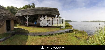 Wexford, Irlande, 18 août 2022 : typique Viking long House avec un bateau reconstruit sur les rives de la rivière Slaney dans le patrimoine national irlandais Banque D'Images