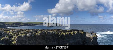 Kilkee, Irlande, 4 août 2022 : paysage panoramique des falaises sauvages de Kilkee avec des pêcheurs audacieux au bord de la falaise, en Europe Banque D'Images