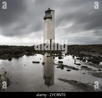 Vue sur le phare historique de la Southerness en Écosse avec réflexions dans les bassins de marée en premier plan Banque D'Images