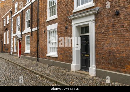 Chester, Royaume-Uni, 26 août 2022 : bâtiments en briques rouges avec des portes colorées à la mode anglaise typique dans le centre-ville historique de Chester, E. Banque D'Images