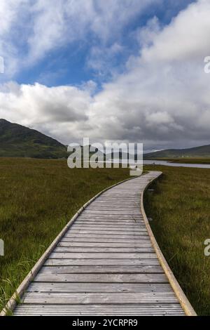 Une vue verticale de la piste côtière de Claggan Mountain et de la promenade avec la chaîne de montagnes Nephir en arrière-plan Banque D'Images