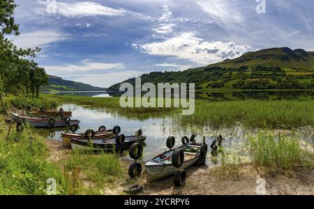 Glencar, Irlande, 16 juillet 2022 : paysage de Glencar Lough avec de nombreux petits bateaux de pêche en bois colorés au bord du lac, en Europe Banque D'Images
