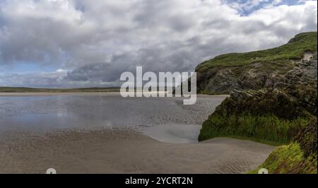 Vue sur la pittoresque plage de sable doré de Maghera avec des rochers et des falaises recouverts d'algues au premier plan Banque D'Images