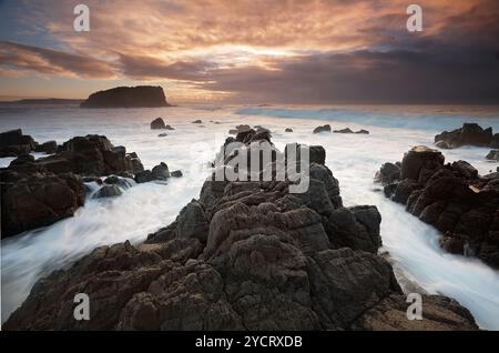 L'océan coule autour de l'affleurement rocheux volcanique de Minnamurra et des vues à travers à Stack Island anciennement une extension des rochers et des falaises ici .. Prise a Banque D'Images