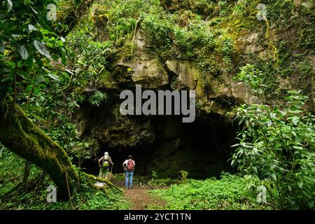 Randonneurs devant une grotte rituelle maya, forêt de nuages sur les pentes du volcan Tolimán, lac Atitlán, Guatemala, Amérique centrale Banque D'Images