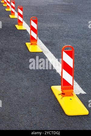 La sécurité de la circulation. Marquage du trafic sur un asphalte gris. Le rouge et blanc à rayures attention road sign Banque D'Images