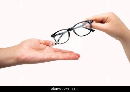 Gros plan sur une main donnant un verre à une autre, isolé sur fond blanc. Banque D'Images
