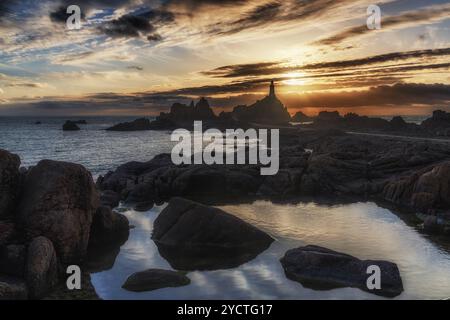 Phare du Corbière au coucher du soleil à marée basse. Réflexion au premier plan. Banque D'Images