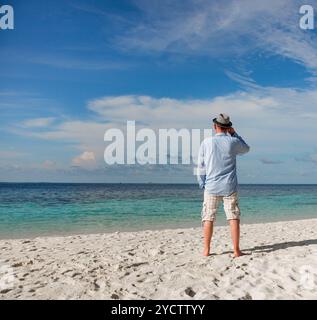 Homme marchant le long d'une plage tropicale aux Maldives. Banque D'Images