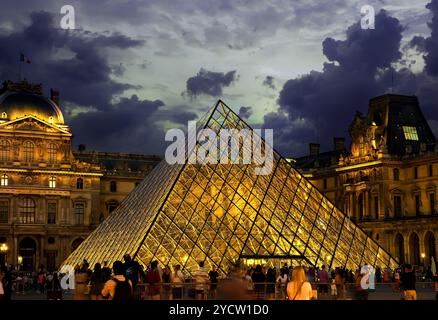 PARIS, FRANCE - Le 26 août 2016. Nuages sur la pyramide illuminée et musée du Louvre dans la soirée Banque D'Images