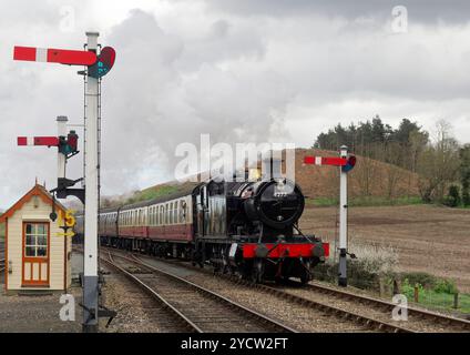 Un ancien moteur de char de classe 42XX de GWR pénètre dans la station Weybourne sur le North Norfolk Railway devant des signaux de sémaphore somersault de style GNR inhabituels. Banque D'Images