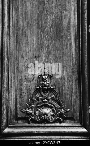 Vieille porte en bois avec sculpture florale. Paris, France. Noir et blanc. Banque D'Images