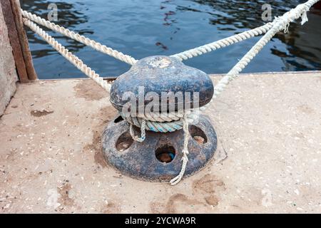 Vieille amarre metal bollard avec une corde fixe à l'embarcadère Banque D'Images