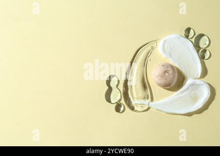 Frottis de différents produits cosmétiques sur fond beige, vue de dessus. Espace pour le texte Banque D'Images