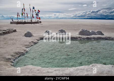 Salt Flats en Bolivie, drapeaux en lambeaux, piscine au sel, Salar de Uyuni, salines stériles, ciel nuageux, paysage sec, venteux, sombre Banque D'Images