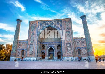 SAMARKAND, OUZBÉKISTAN - 28 août : Ulugh Beg madrasah du Reghistan dans le coucher du soleil avec des gens en face d'elle. Samarkand, Août 2016 Banque D'Images