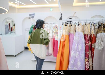 Un couple coréen, un homme de 30 ans et une femme de 20 ans, choisissent harmonieusement des vêtements à porter dans un magasin de location de hanbok à Séoul, en Corée du Sud. Banque D'Images