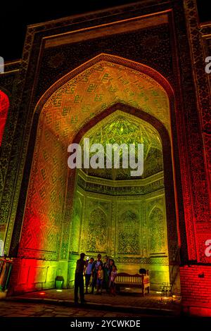 SAMARKAND, OUZBÉKISTAN - 28 Août : Les personnes qui prennent des photos dans l'atrium de Sher Dor madrasah de nuit, Reghistan, Samarkand. Août 2016 Banque D'Images